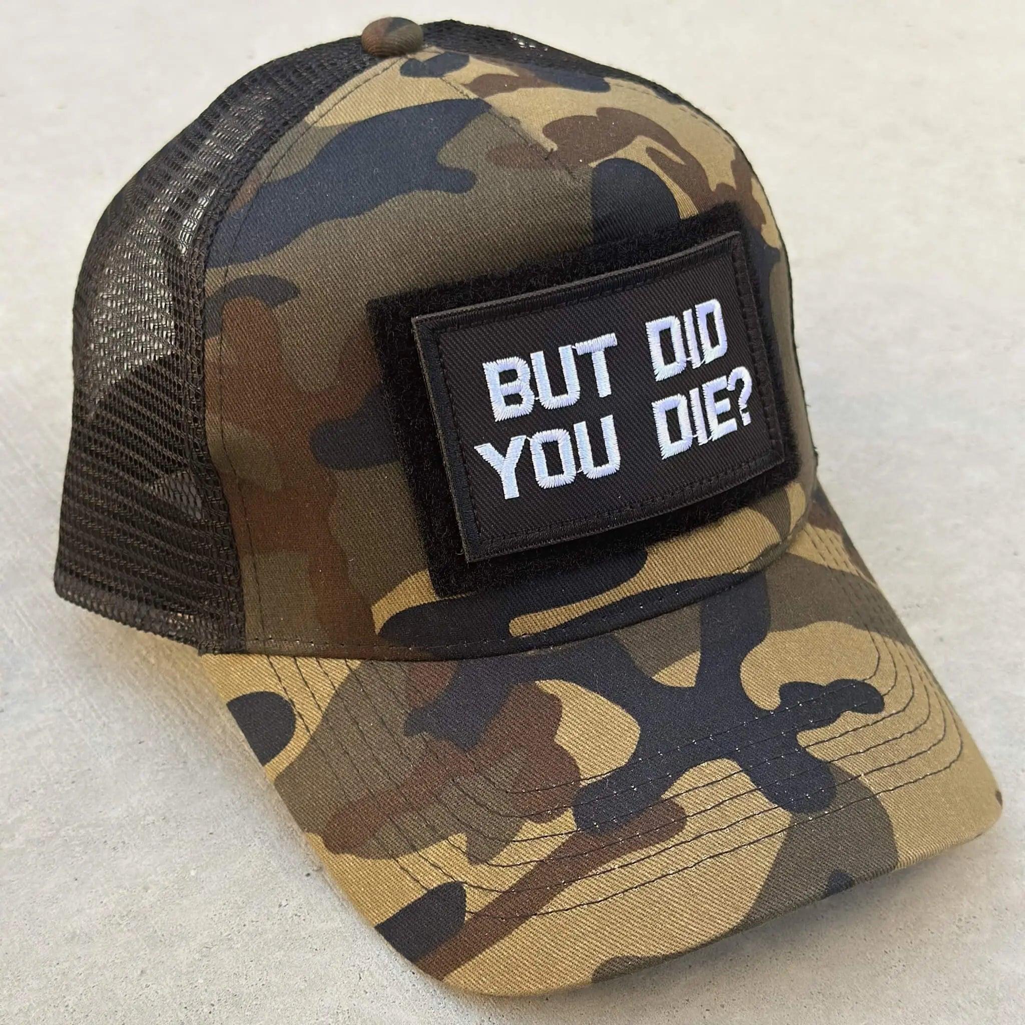 The trucker snapback cap in camo color with But Did You Die patch attached