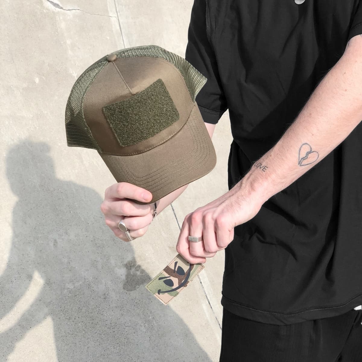 Model holding the Smiley Cap with the patch off
